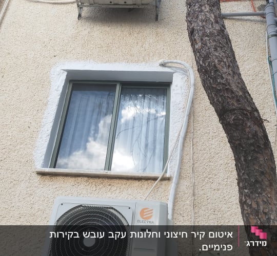 חלון אטום עם חומר איטום לבן סביב המסגרת